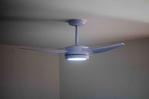 a ceiling fan with a light in a room at Luxo com Spa exclusivo no paraíso do Peró! in Cabo Frio