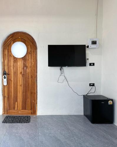 a flat screen tv on a wall next to a door at Megun 10 in Ban Bang Phlat