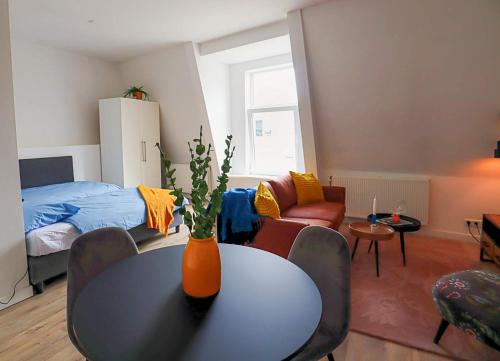 a living room with a table and a bedroom at Saftliving in Rotterdam