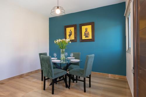 a dining room with a blue wall and a table and chairs at Modern Townhouse with pool ten minutes Limassol Center in Limassol