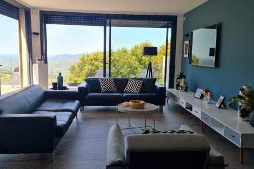 - un salon avec des canapés et une grande fenêtre dans l'établissement Villa climatisée vue mer piscine privée chauffée wifi 810 personnes, à Sollacaro