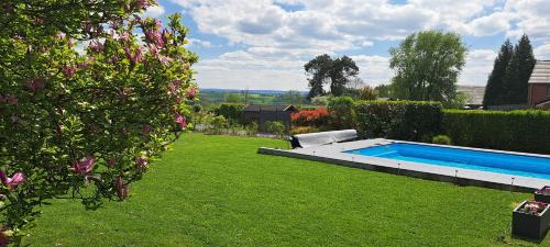 a backyard with a swimming pool in a yard at Au coin du hérisson in Olne