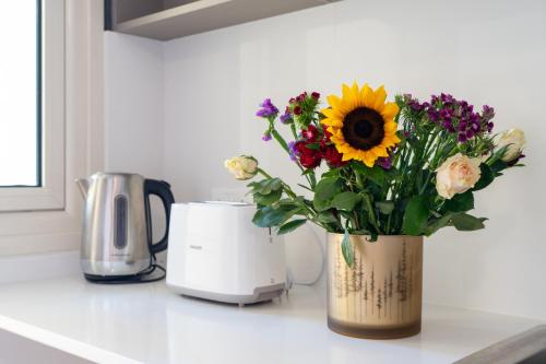 a vase of flowers sitting on a kitchen counter at Modern Townhouse with pool ten minutes Limassol Center in Limassol