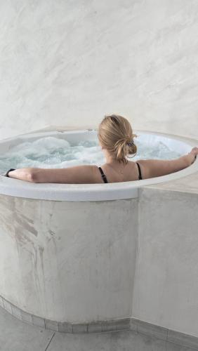 a woman in a jacuzzi in a pool at Sea Baltic Apartament Gąski - basen in Gąski