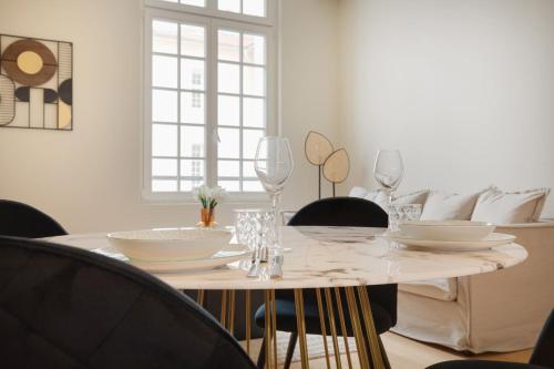 une salle à manger blanche avec une table et des chaises blanches dans l'établissement Appartement Place de Gaulle - Welkeys, à Antibes