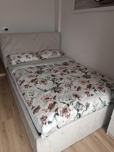 a bed in a bedroom with a floral bedspread at CoCo Apartment in Ljubljana