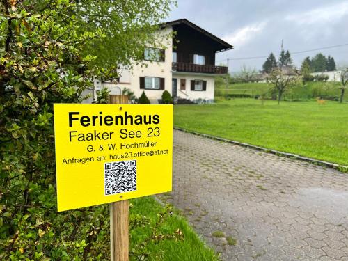 a yellow sign on a pole in front of a house at Ferienhaus Faaker See 23 in Faak am See