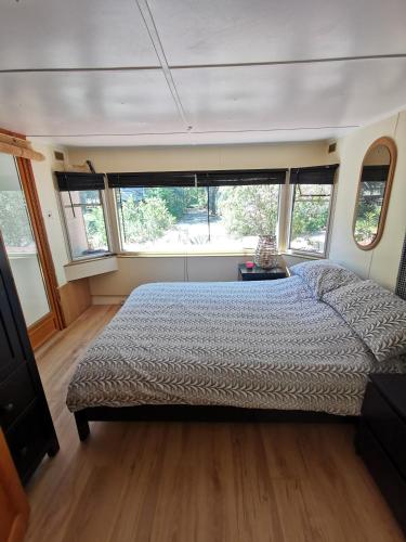 une chambre avec un lit dans une pièce avec des fenêtres dans l'établissement Évasion tout confort pour 4 - Domaine avec 5 piscines & activités !, à Fréjus