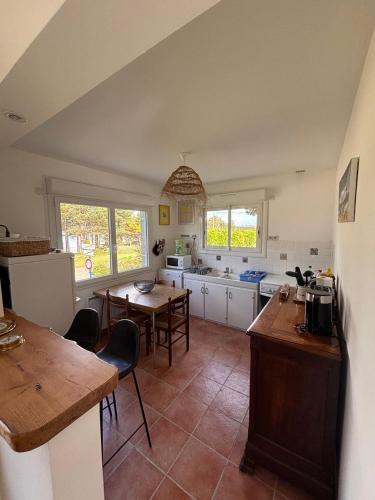 une cuisine avec une table et quelques chaises dans l'établissement Locquirec Les pieds dans l'eau 6 personnes, à Locquirec