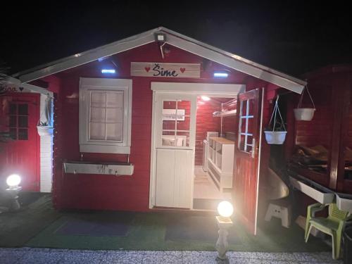 a red house with a door and lights on it at Apartments and bungalows vila Dalibor in Nin