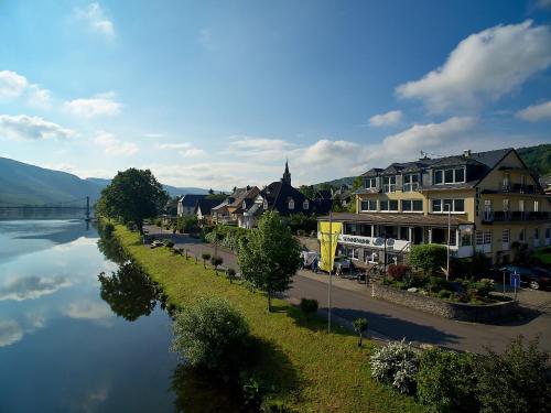 a town next to a river with houses and a bridge at Sonnenuhr in Bernkastel-Kues