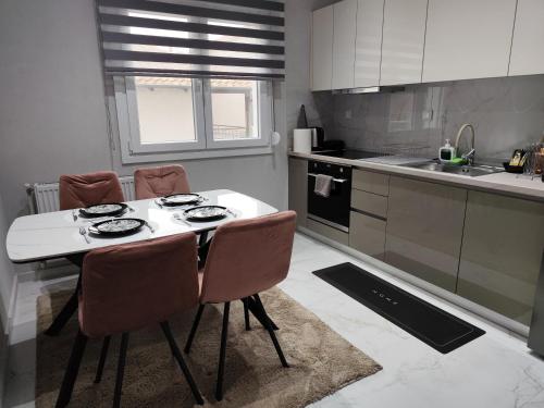 a kitchen with a white table and chairs in it at Twin Stars in Drama