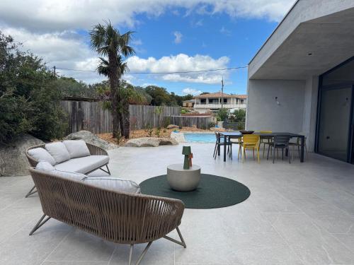 d'une terrasse avec un canapé, des chaises et une table. dans l'établissement La petite maison Corse, à Porto-Vecchio
