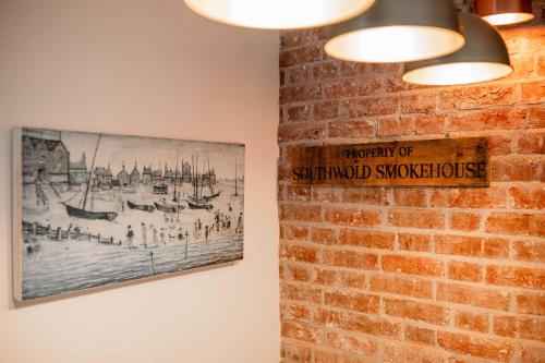 a sign on a brick wall with a picture on it at Bramley House Apartment in Southwold
