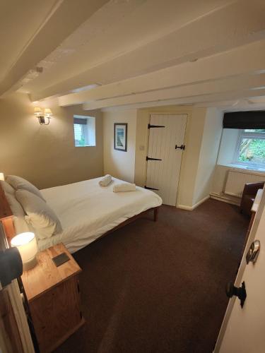 a bedroom with a large white bed and a window at The Mill House in Tintagel