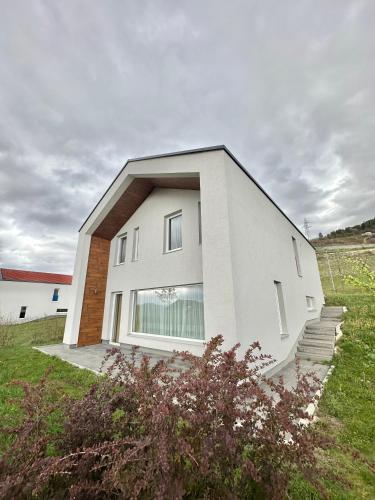 a white house with stairs in a field at Villa Poljine Hills A80 in Sarajevo