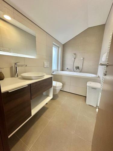 a bathroom with a sink and a tub and a toilet at Villa Poljine Hills A80 in Sarajevo