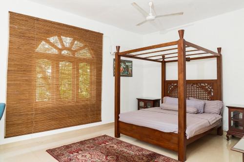 une chambre avec un lit à baldaquin et une fenêtre dans l'établissement Villa Ceylonia, à Negombo