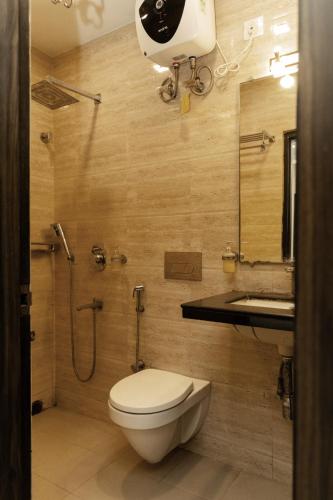 a bathroom with a toilet and a sink and a shower at Sheldon Inn Kolkata in Kolkata