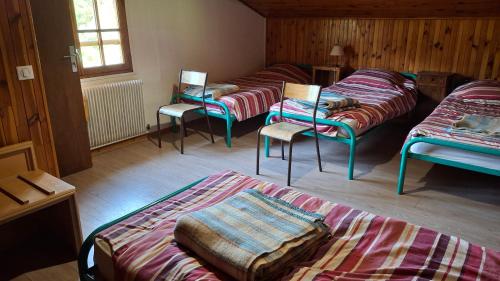 une chambre avec quatre lits et des chaises dans une pièce dans l'établissement Chalet de caractère, à Alex