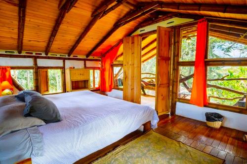 a bedroom with a large bed in a room with windows at Hotel La Casa de Francois in San Agustín