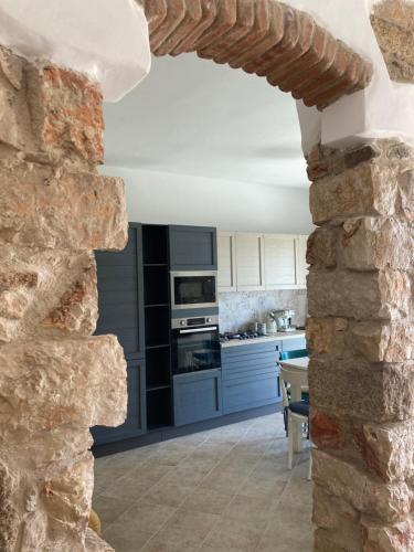 a kitchen with a stone wall and a stone oven at Sa Dommu e Mare in Santa Maria Navarrese