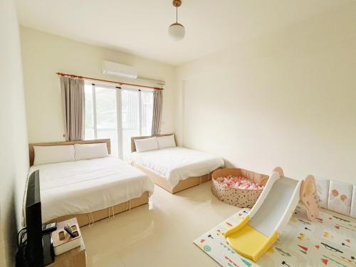 ein Schlafzimmer mit 2 Betten und einem Stuhl darin in der Unterkunft The Kite in Taitung