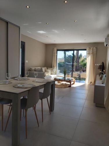 une salle à manger et un salon avec une table et des chaises dans l'établissement Paisible vacance proche de la mer, au Grau-dʼAgde