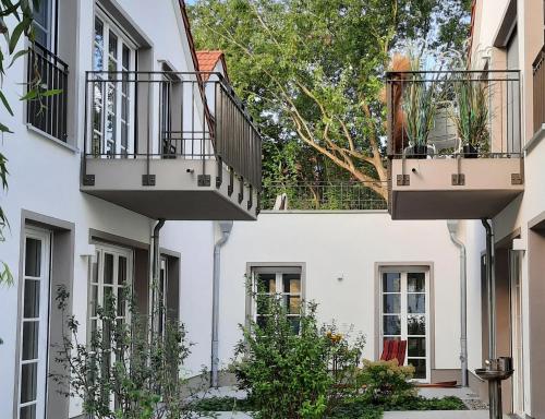 two balconies on a white building with plants at Seeapartment Wustrau in Wustrau
