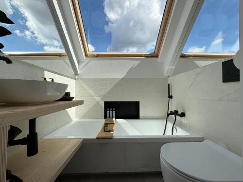 a bathroom with a tub and a sink and a window at Yama Krywe in Krywe