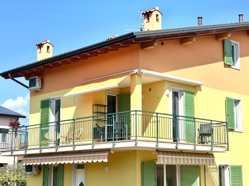 a yellow building with balconies and a balcony at La Casetta Lazise in Lazise