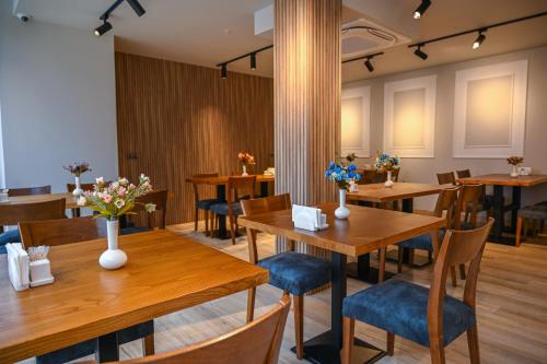 a dining room with wooden tables and blue chairs at Landmark Hotel in Batumi