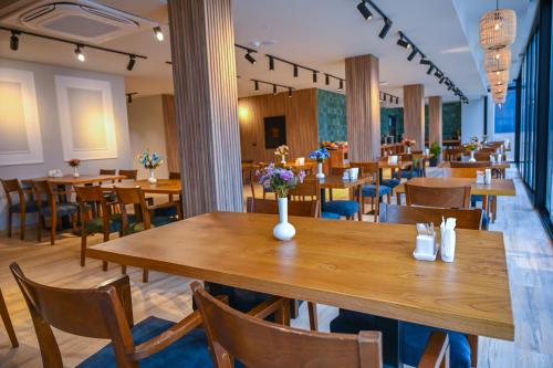 a dining room with wooden tables and chairs at Landmark Hotel in Batumi