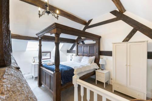 a bedroom with a canopy bed with a blue comforter at OYO Blenheim House in Etwall