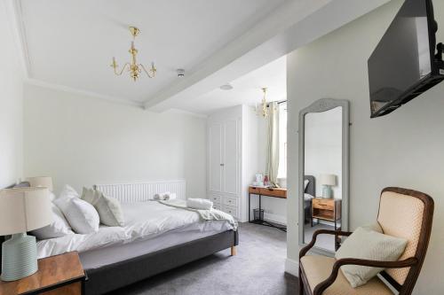 a bedroom with a bed and a mirror and a chair at OYO Blenheim House in Etwall