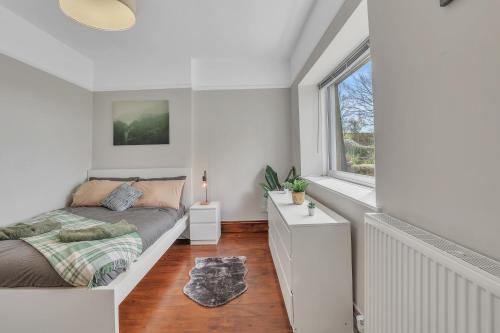 een slaapkamer met een bed en een raam bij Cozy 2 Bedroom Cottage in West Woodburn