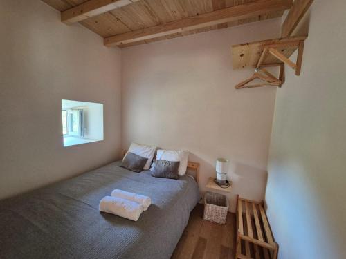 a bedroom with a bed with two towels on it at Beija Rio Charming House in Ferreira do Zêzere