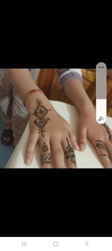 a child with tattoos on their hands on a table at Maroc Galacx in Ouarzazate