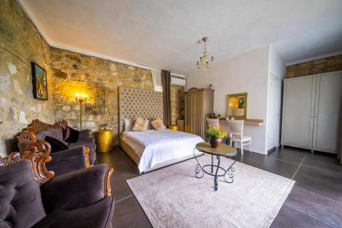 a bedroom with a bed and a living room at Assosa Country House in Ayvacık