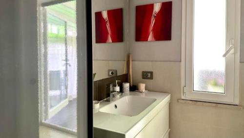 a bathroom with a white sink and a window at Appartamento via Raffaello Sanzio in Senigallia