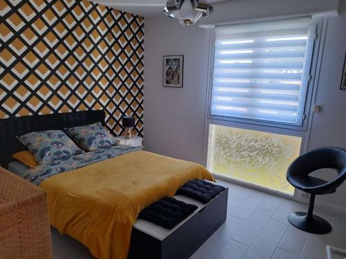 une chambre avec un lit, une chaise et une fenêtre dans l'établissement Appartement T2 à 300m du marché - Balcon, cuisine équipée, chambre confort, idéal vacances. - FR-1-494-183, à Royan