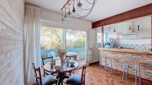 une cuisine avec une table et des chaises ainsi qu'une fenêtre dans l'établissement V-Sable d'or 01-Vieux Boucau Appartement 3 pièces proche de l'océan, à Vieux-Boucau-les-Bains