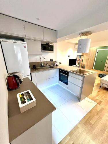 une cuisine avec des armoires blanches et un comptoir dans l'établissement Studio La Baronne, à Cannes