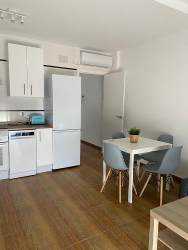 a kitchen with white appliances and a table and chairs at Apartamento Happy Street 3 in Socuéllamos