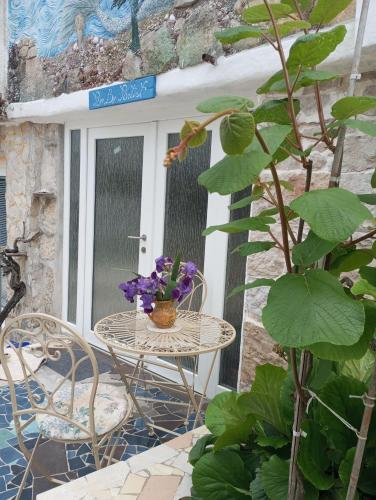 a table and chairs with flowers on a patio at By Artist in Pićan