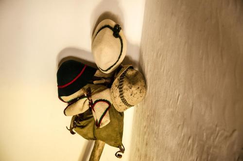 a bunch of hats hanging on a wall at B&B Rossodisera in Domegge di Cadore