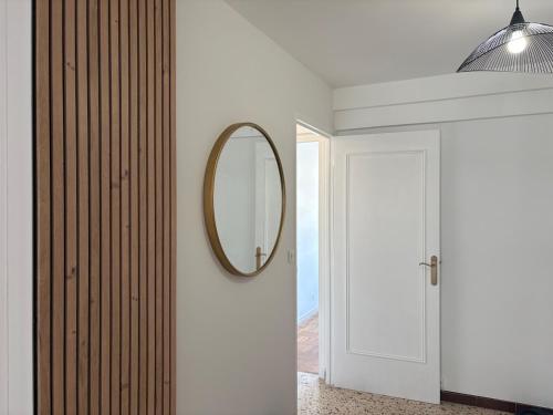 un couloir avec un miroir et une porte blanche dans l'établissement Spacieux 4P familial renové, à Nice