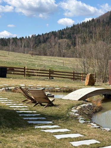 a wooden bench sitting on the grass next to a bridge at Yama Krywe in Krywe