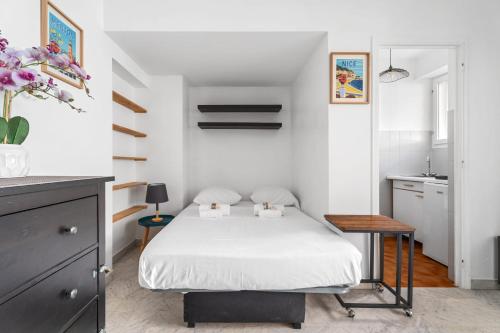 une petite chambre avec un lit et une table dans l'établissement Studio Malaussena - Welkeys, à Nice