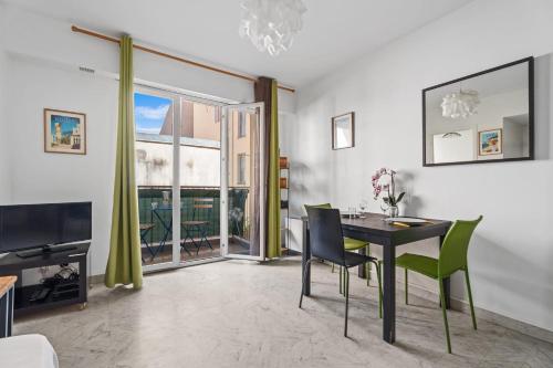 une salle à manger avec une table et des chaises vertes dans l'établissement Studio Malaussena - Welkeys, à Nice